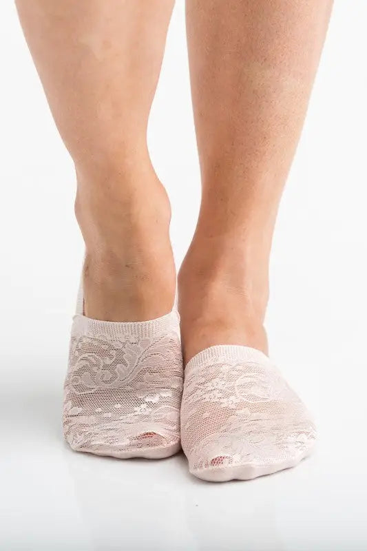 Two feet wearing sheer floral lace sneaker socks with holes in the toe areas