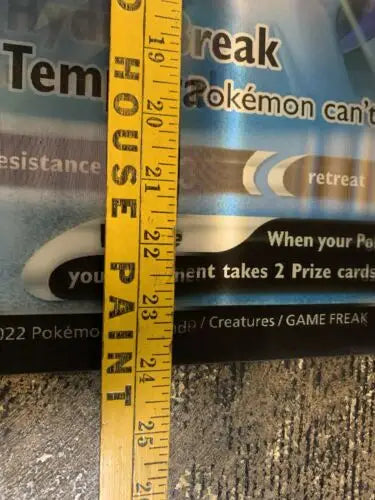 Yellow measuring stick beside Pokemon Astral Radiance Dialga Palkia store promo poster