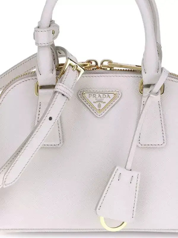 Light pink Prada leather handbag with gold hardware, logo patch, and zip closure