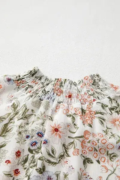 White floral print smocked top with a printed mock neck and long sleeve design