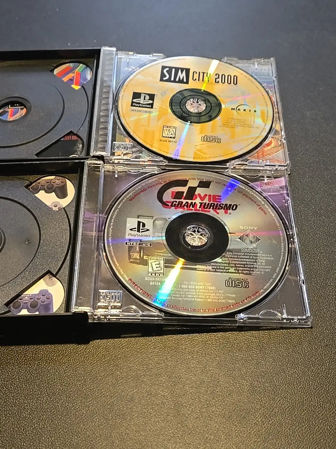 PlayStation game discs in cases for Sim City 2000 and Gran Turismo Greatest Hits