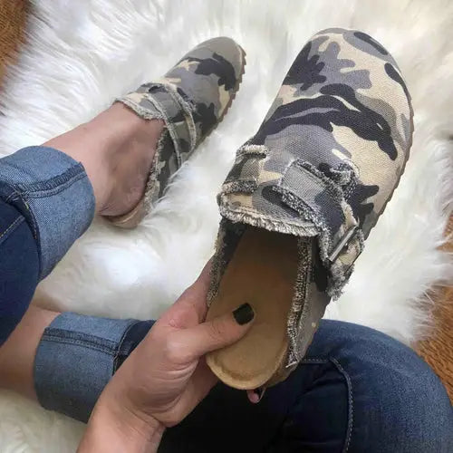 Pair of women’s camouflage print RetroCharm Canvas Loafer Clogs with frayed details
