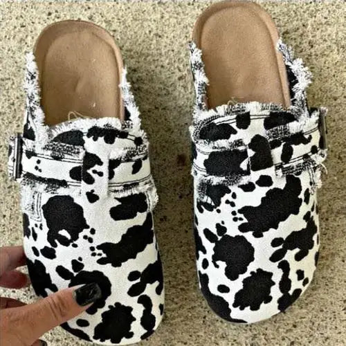 Pair of cow-print RetroCharm Canvas Loafer Clogs with frayed edges and buckle accent