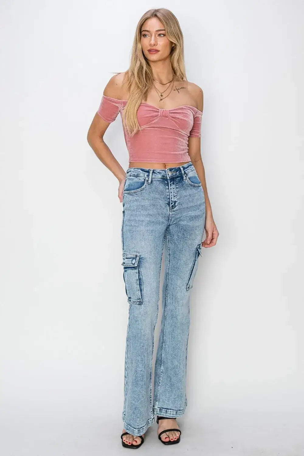 Woman modeling RISEN Full Size High Rise Cargo Flare Jeans and pink velvet crop top