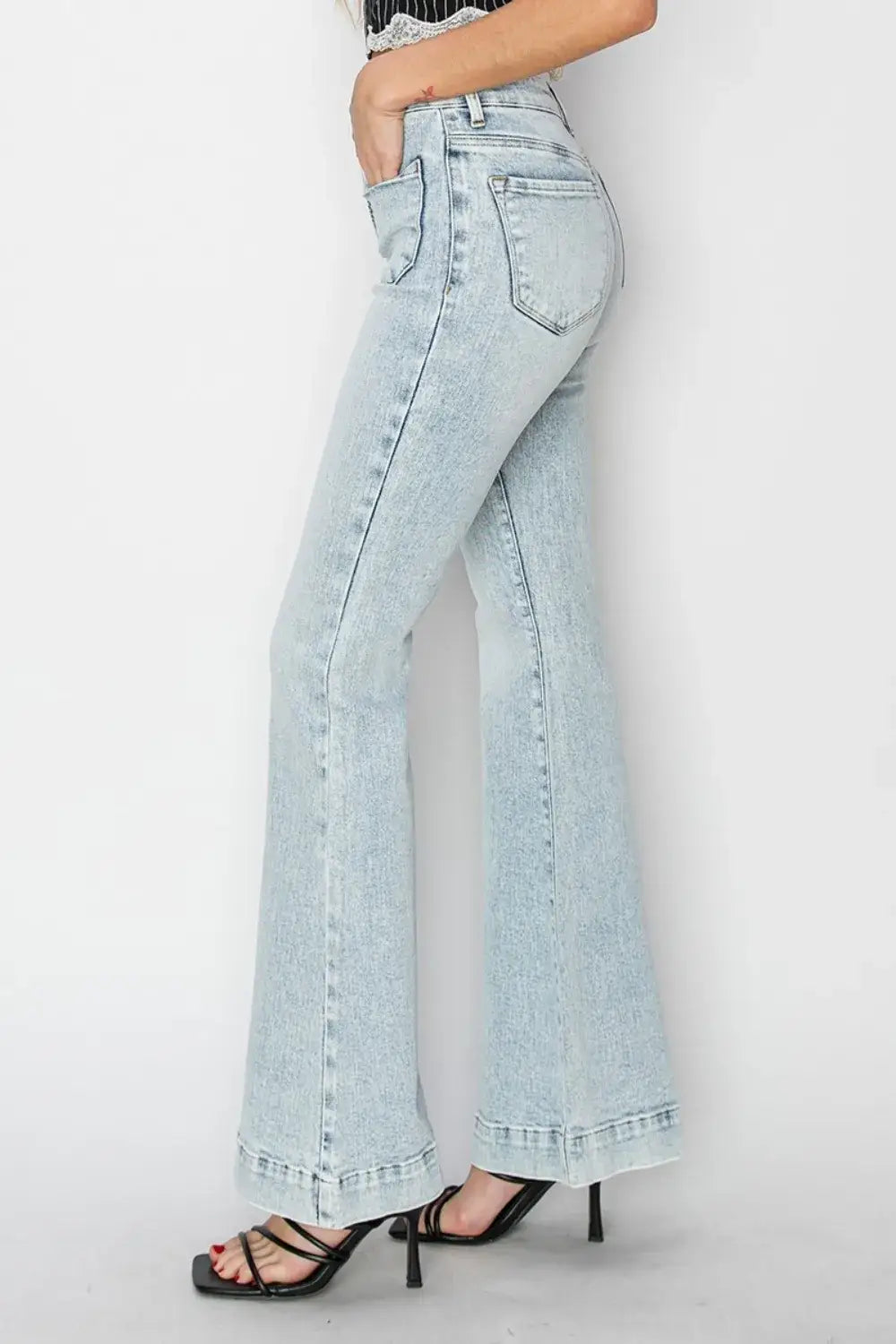 Light wash high-rise patch pocket flare jeans with frayed hems and black strappy heels