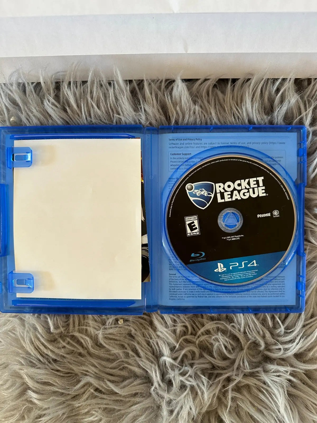 Open blue Rocket League Ultimate Edition PS4 case with disc inside