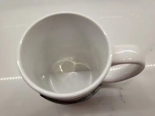 Empty white ceramic coffee mug featuring Seattle Seahawks raised logo design