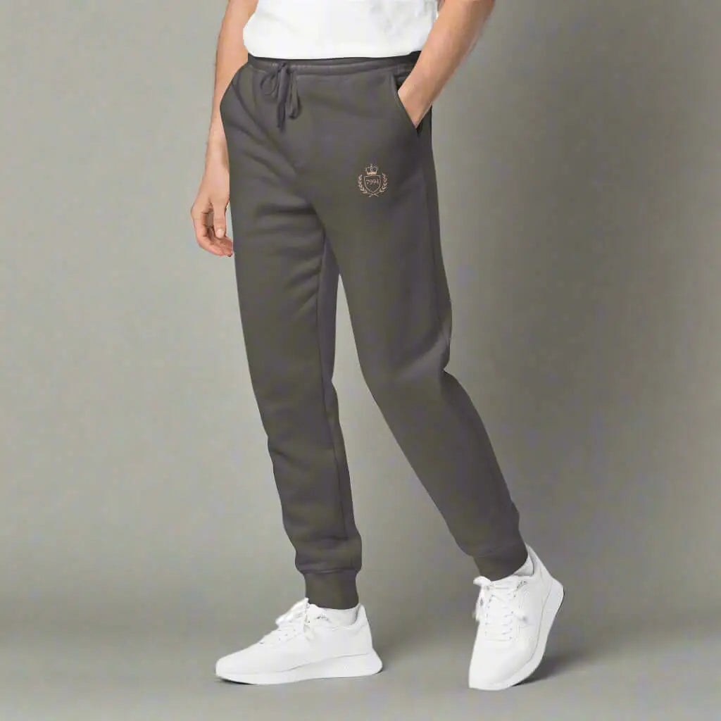 Men’s dark grey Crested Luxe Joggers with drawstring waist and white sneakers