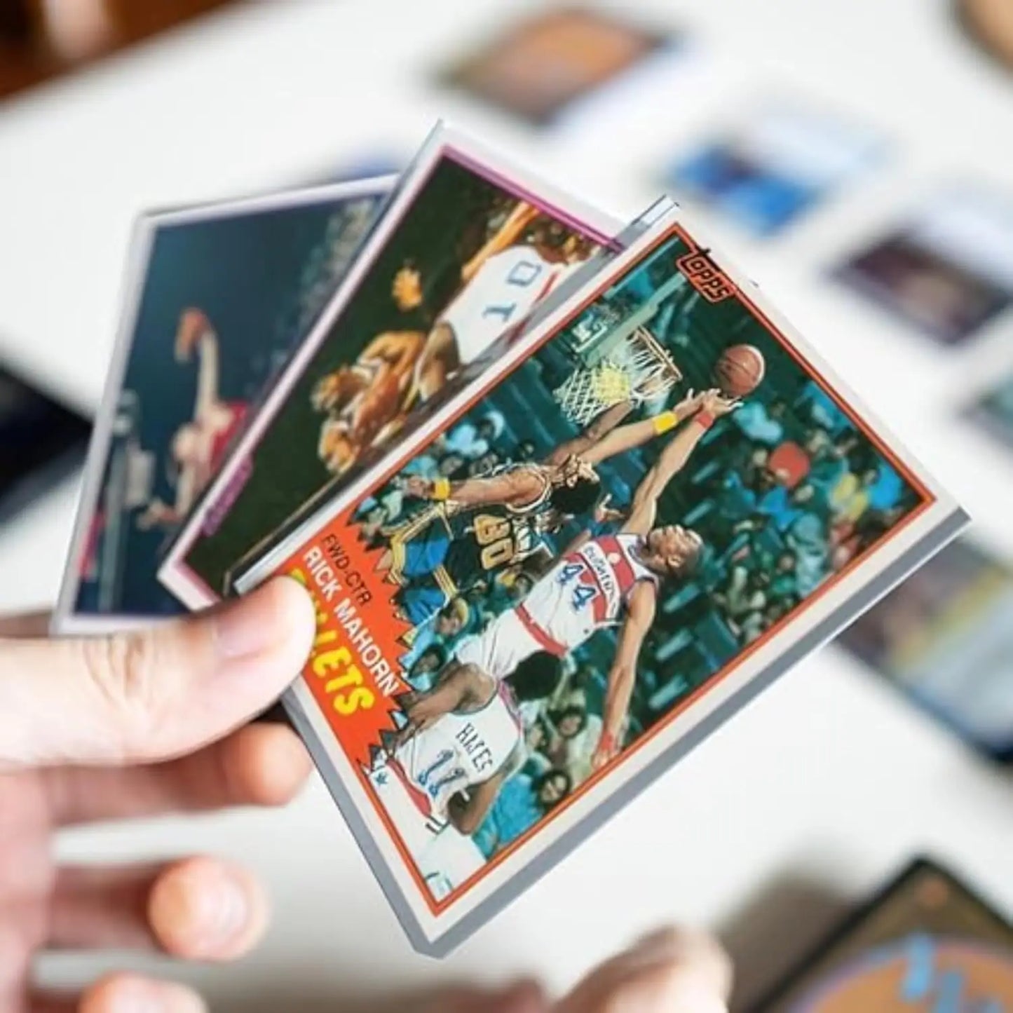 Hand holding basketball cards with Toploader Collector Bundle for card protection