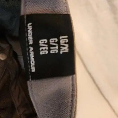 Under Armour hat clothing size tag showing L/XL Flex Stretch Fitted Olive Green armor hat