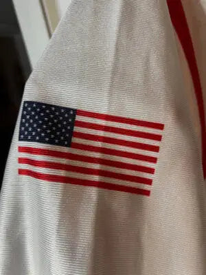 Embroidered American flag patch on white fabric of Under Armour White Men’s Jersey XL