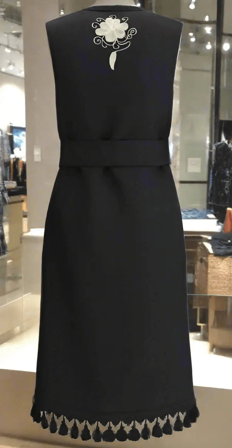 Black sleeveless embroidered long vest with white floral embroidery and tasseled hem
