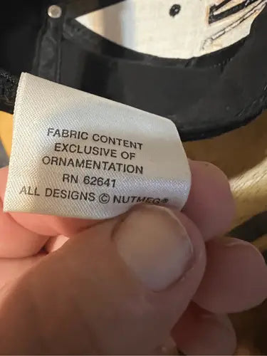 White clothing tag with care instructions on Vintage Nut Meg Ernie Irvin NASCAR racing snapback hat