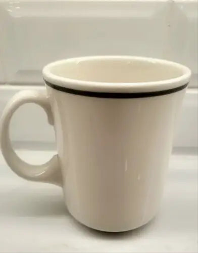 Cream-colored china coffee mug with black rim featuring England Patriots logo