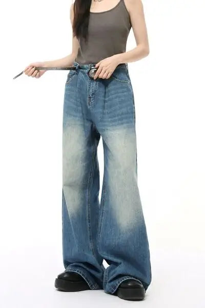 Dark gray ribbed tank top and distressed wide-leg blue jeans with silver belt buckle