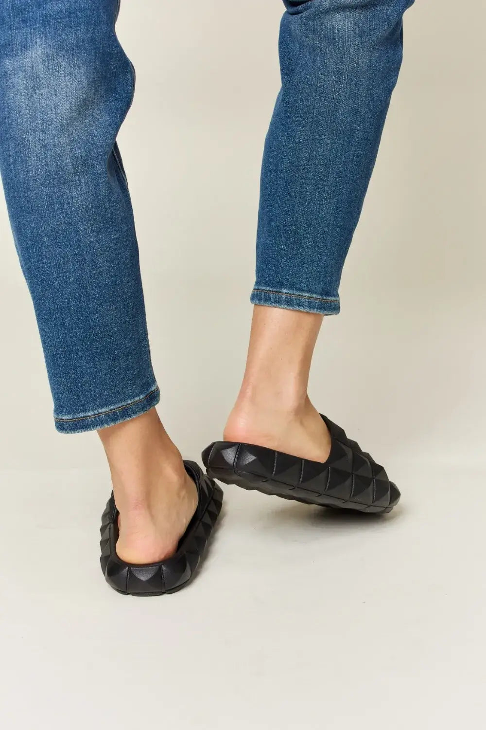 Person’s legs wearing cropped blue jeans and WILD DIVA Pyramid Stud Toe Band Footbed Sandals