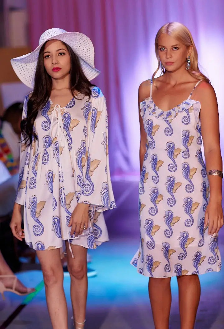 Women modeling white mini dress with blue and yellow seahorse pattern and flare sleeves