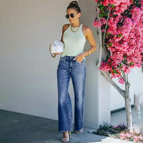 Woman modeling loose fit high stretch wide leg denim pants with light green halter top