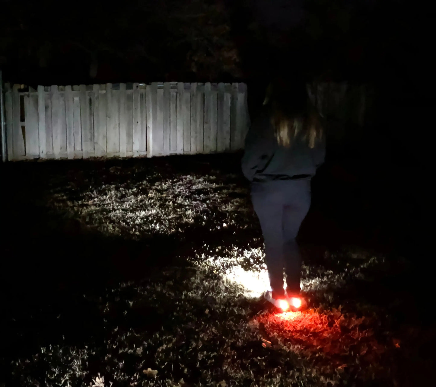 Women’s Night Runner Shoes with built-in safety lights illuminating a dark grassy area