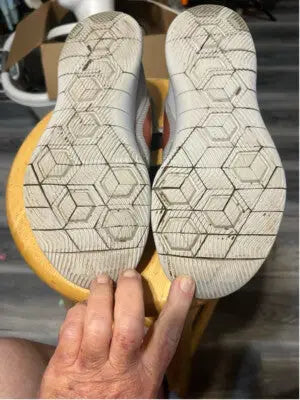 Alt text for Women’s Nike Flex Contact Running Shoes showing white soles with hexagonal tread pattern