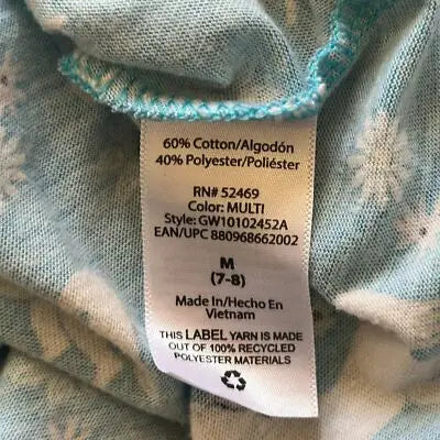 Clothing label on patterned fabric of Wonder Nation Girls Blue Unicorn Dress size 7/8