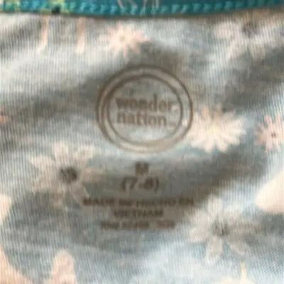 Light blue fabric with white daisy-like flowers on Wonder Nation Girls Blue Unicorn Dress