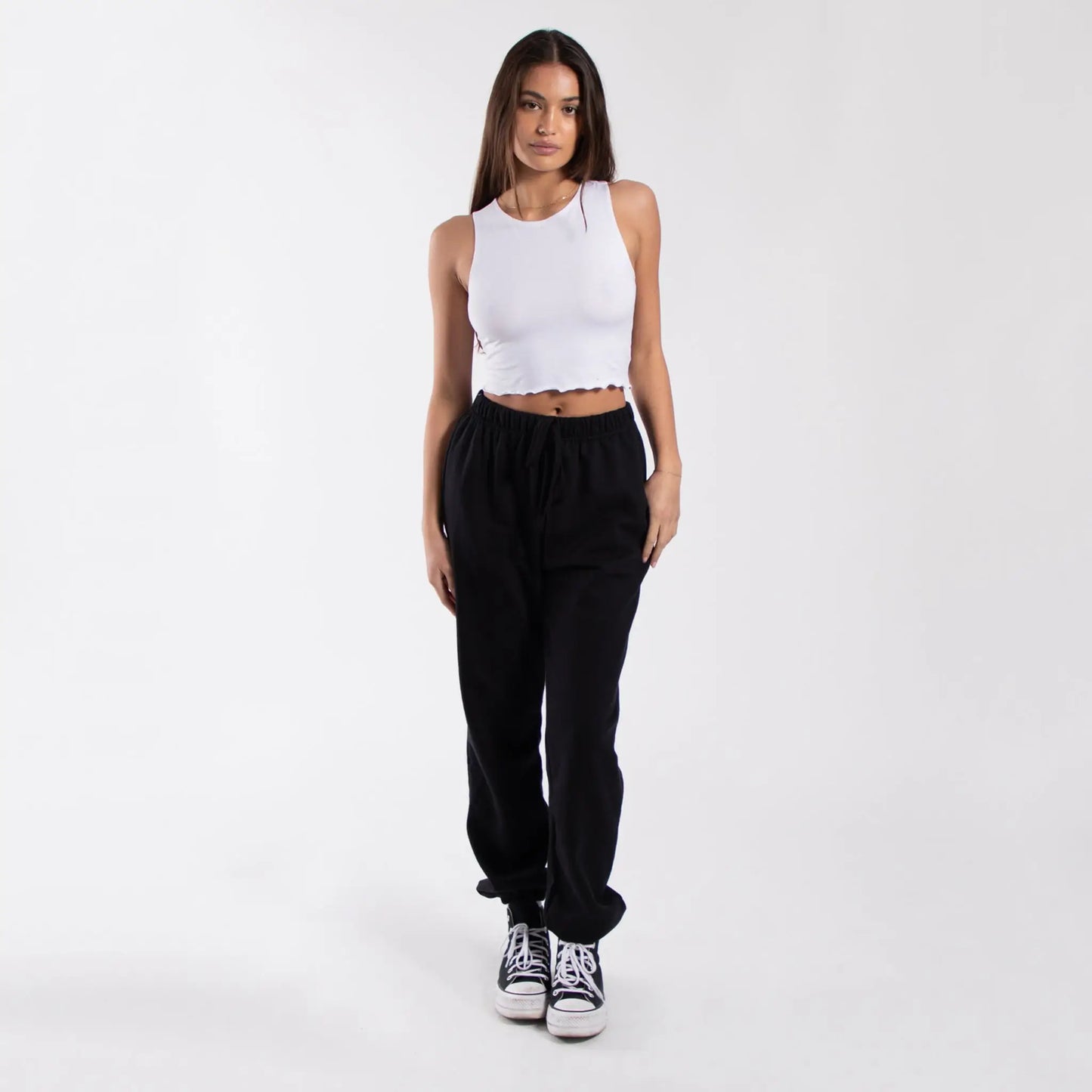 Black corduroy jogger pants with white Converse sneakers and a cropped lettuce trim muscle tank from info otlapparel