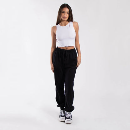 Black corduroy jogger pants with white Converse sneakers and a cropped lettuce trim muscle tank from info otlapparel