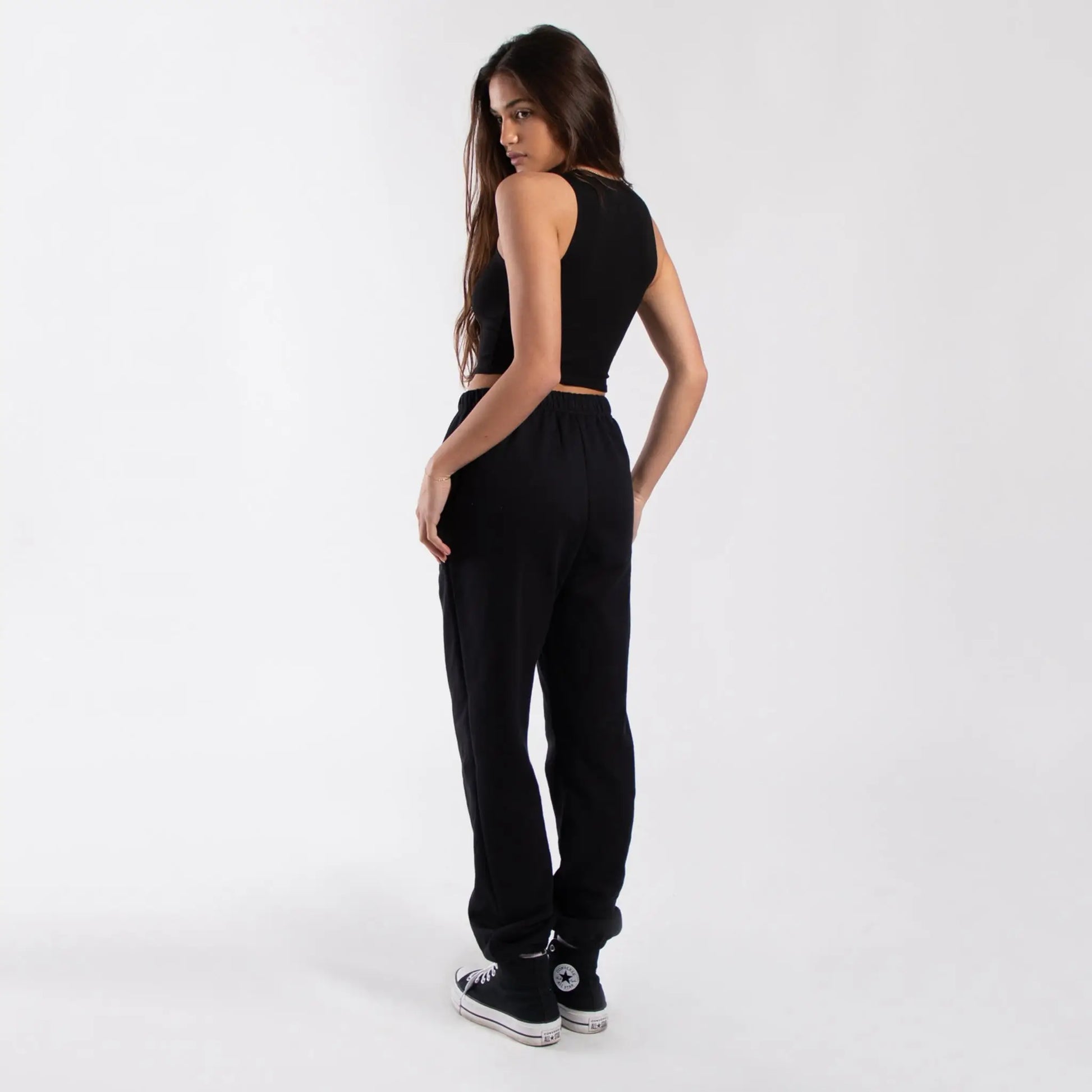 Black cropped formfitting muscle tank with white Converse sneakers and loose black pants info otlapparel
