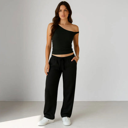 Black one-shoulder crop top with matching sweatpants and white sneakers for info otlapparel