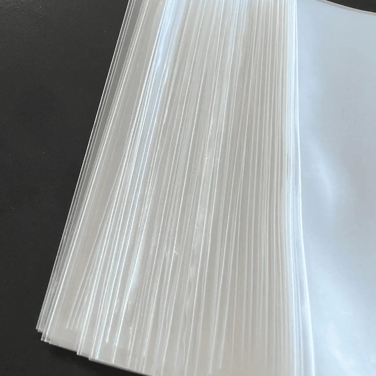 Stack of clear plastic Max Pro card sleeves for standard size trading cards