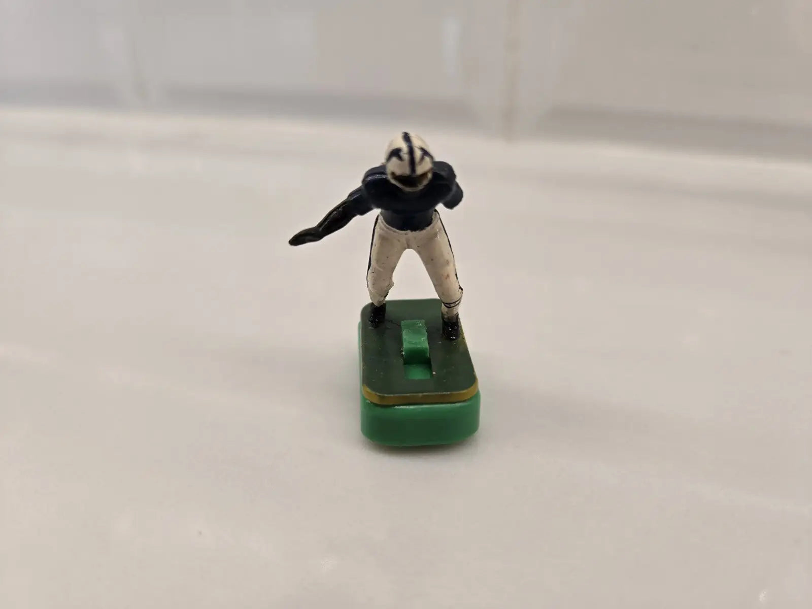Toy football player on green base from Indianapolis Colts Electronic Football set