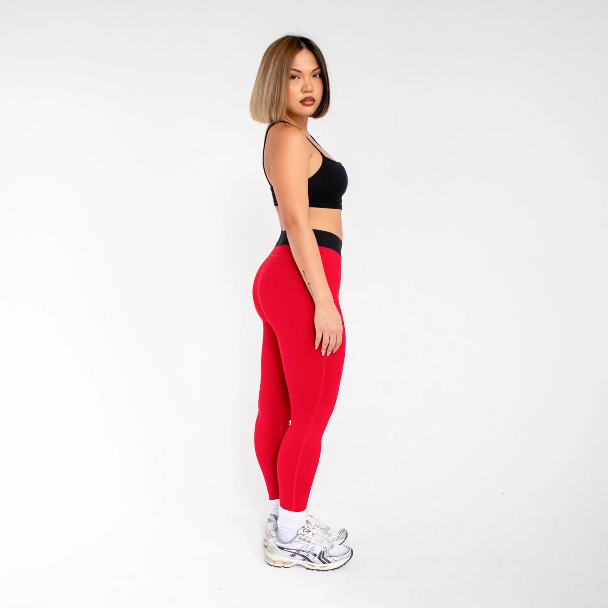 Red leggings with black waistband and white sneakers from 1000BD Women’s Banded Pro Legging info otlapparel