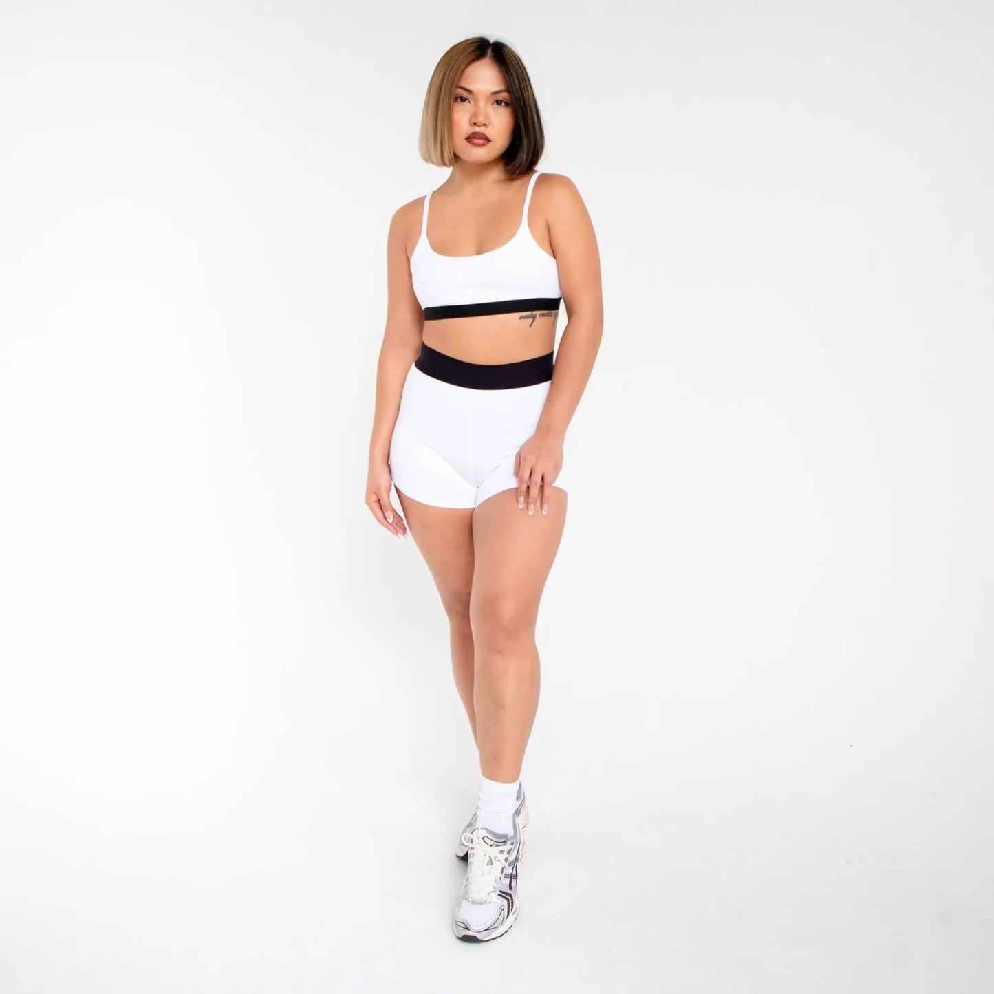 White athletic shorts with black waistband and silver sneakers from 1001BD info otlapparel