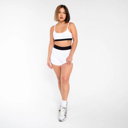 White athletic shorts with black waistband and silver sneakers from 1001BD info otlapparel
