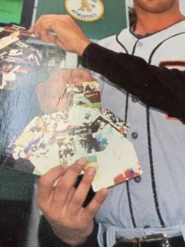 Baseball trading cards featuring Jose Canseco held in hand from a store display