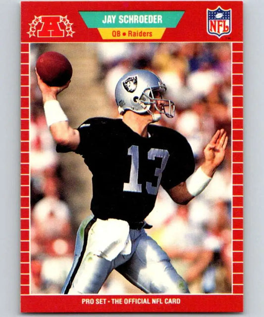 Jay Schroeder in black jersey #13 throwing a football for the Los Angeles Raiders