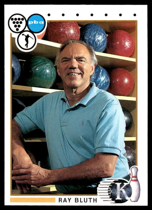 Person in light blue polo shirt next to bowling balls and Ray Bluth PBA Bowling Card