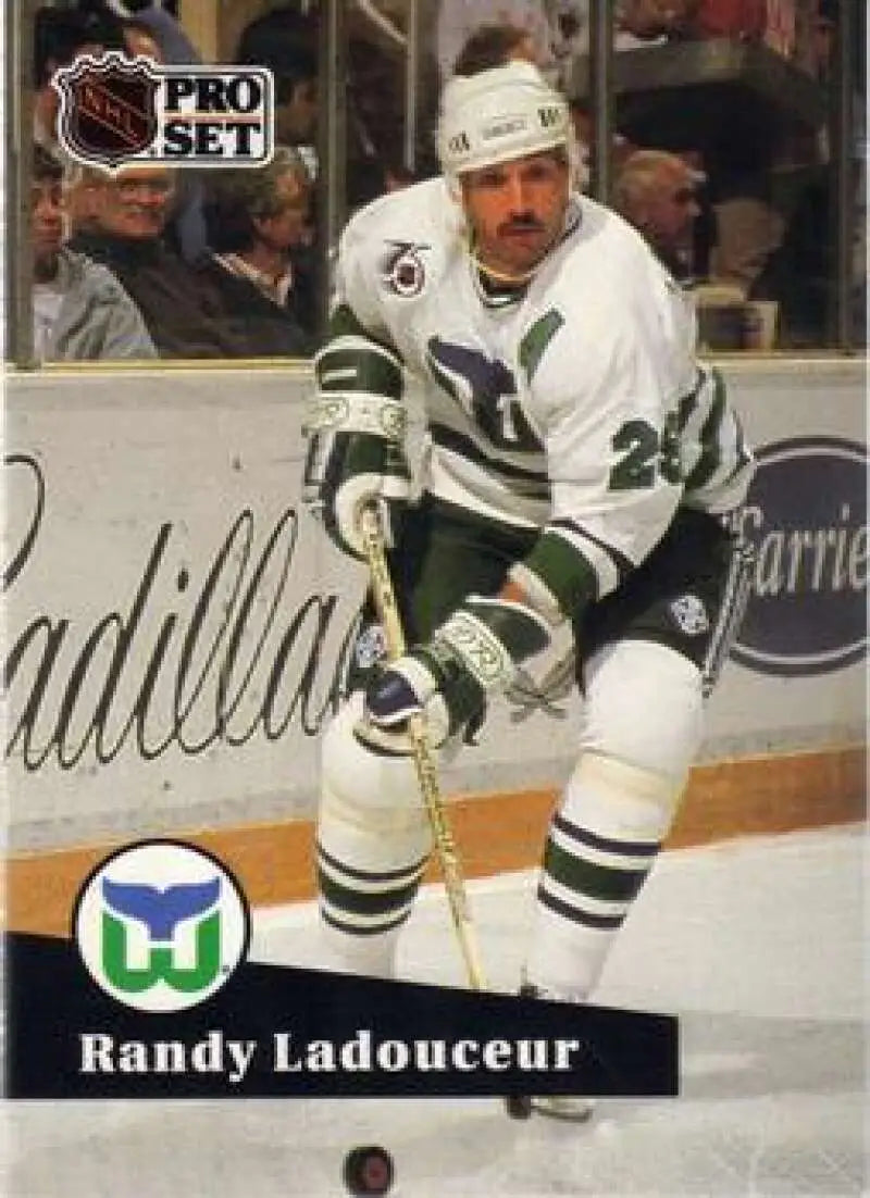 Hockey player in a white Hartford Whalers jersey skating with a stick, Randy Ladouceur