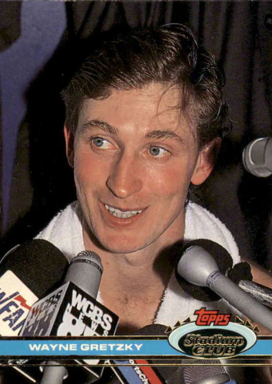 Wayne Gretzky smiling during a press interview with microphones at Los Angeles Kings event