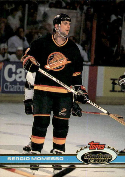 Sergio Momesso in a Vancouver Canucks jersey with a hockey stick on a sports card