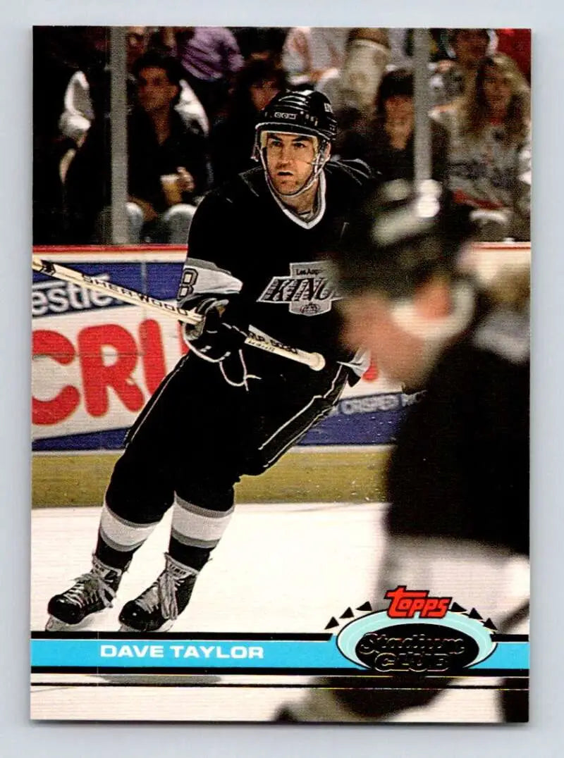 Hockey player in a black Los Angeles Kings jersey, showcasing Dave Taylor in action