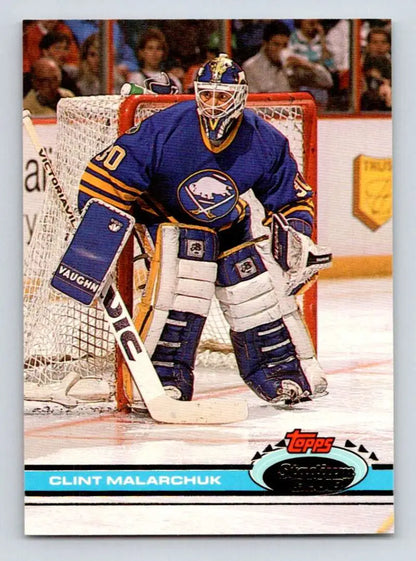 Hockey goalie in blue Buffalo Sabres jersey showcasing Clint Malarchuk Topps Stadium Club card