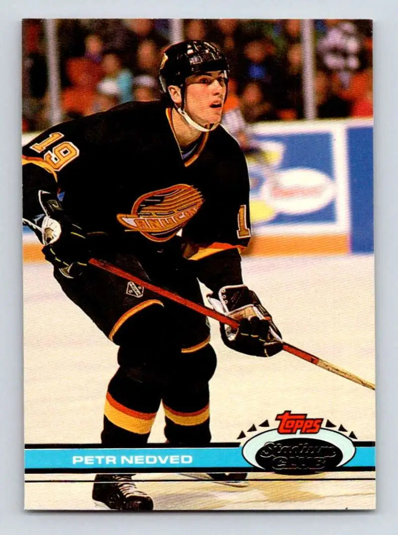 Hockey player in black Vancouver Canucks jersey skating with stick, featuring Petr Nedved