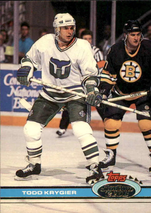 Hockey player in a Hartford Whalers jersey defended by a Boston Bruins player