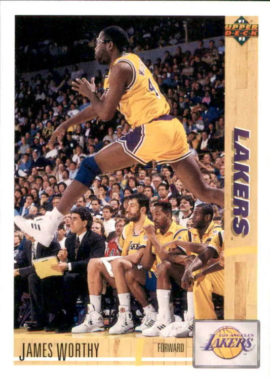 James Worthy leaps in a Lakers uniform near the bench, showcasing his athleticism