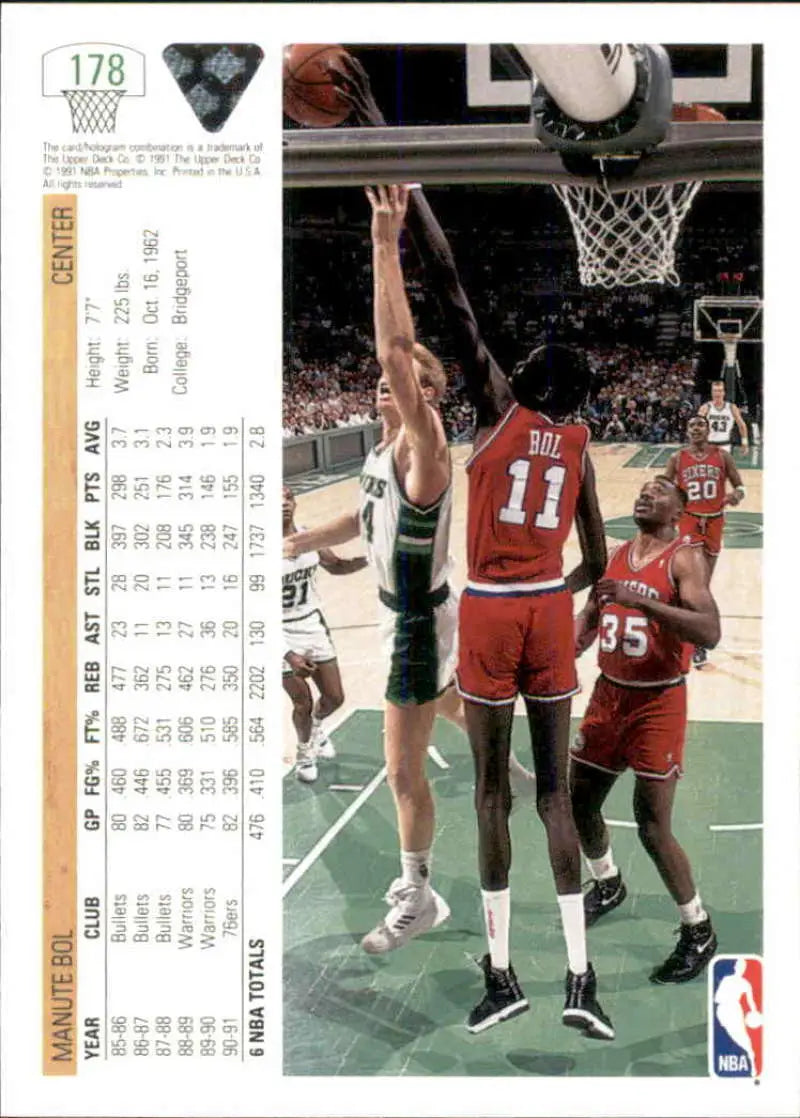 Action shot of Philadelphia 76ers players competing for a rebound featuring Manute Bol