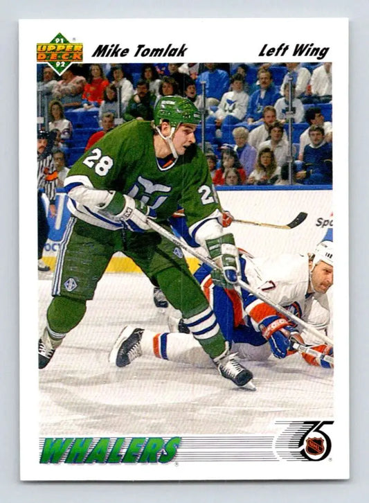 Hockey player in Hartford Whalers jersey skates past fallen opponent, Mike Tomlak card