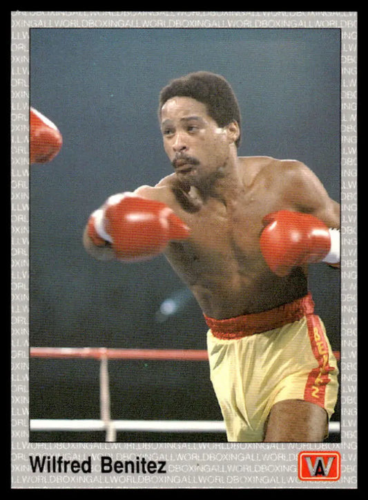 A boxer in yellow shorts throwing punches in red gloves for Wilfred Benitez boxing card