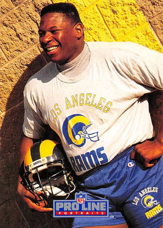 Person in Los Angeles Rams t-shirt holding football helmet near Jackie Slater Pro Line Portraits card